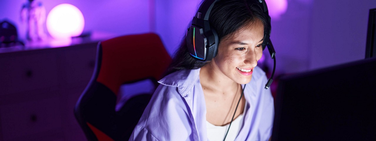tech support woman in purple shirt wearing headphones and looking at computer 