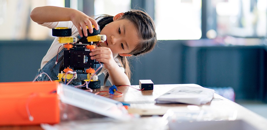 Young girl working on a robot